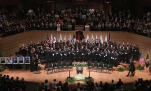 U.S. President Barack Obama and first lady Michelle Obama walk across the stage at an interfaith memorial service, honoring five slain police officers at the Morton H. Meyerson Symphony Center on July 12, 2016 in Dallas, Texas. (Credit: Tom Pennington/Getty Images)