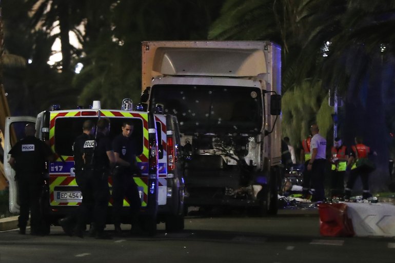 Police officers stand near a vehicle -- its windshield riddled with bullets -- that plowed into a crowd leaving a fireworks display in the French Riviera town of Nice on July 14, 2016. (Credit: VALERY HACHE/AFP/Getty Images)