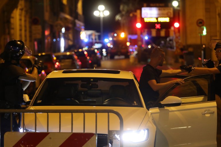 Police officers carry out checks on vehicles in the center of French Riviera town of Nice, after a vehicle drove into a crowd watching a fireworks display on July 14, 2016. (Credit: VALERY HACHE/AFP/Getty Images)