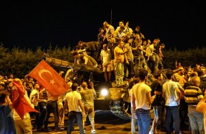 People gather on top of a Turkish army's tank at Ataturk Airport on July 16, 2016 in Istanbul, Turkey. (Credit: Defne Karadeniz/Getty Images)