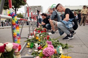 People lay flowers and candles near the crime scene outside the OEZ shopping center the day after a shooting spree left nine victims dead on July 23, 2016 in Munich, Germany. (Photo by Johannes Simon/Getty Images)