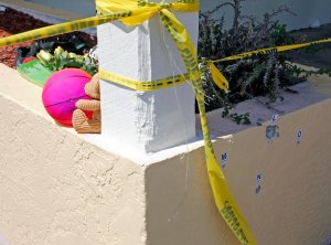 A small memorial begins near where bullet holes are marked outside of Club Blu where two people were killed and at least 15 wounded on July 25, 2016, in Fort Myers, Florida. (Credit: Mike Carlson/Getty Images)
