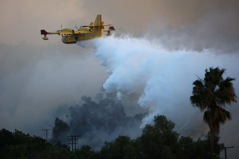 A firefighting Super Scooper airtanker drops water over the Brea Fire on Nov. 15, 2008, near Yorba Linda. (Credit: David McNew/Getty Images)