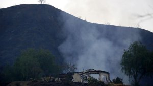 A smoldering home off the 26700 block of Iron Canyon Road is seen on the morning of July 24, 2016. (Credit: Francine Orr / Los Angeles Times)