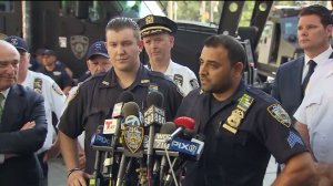 NYPD Officer Peter Cybulski, left, and Sgt. Hameed Armani, right, talk about the terrifying moment a suspected bomb was thrown in their patrol vehicle in Times Square on July 20, 2016. (Credit: WPIX)