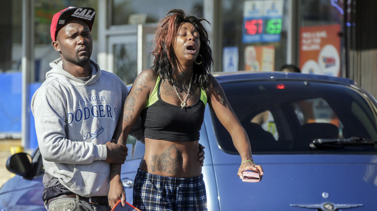 Grieving stepfather Leonard Grant, 27, left, and Ebony Neman, 27, mother of 9-year-old Travon Williams in front of the liquor store where the shooting occurred. (Credit: Irfan Khan / Los Angeles Times)