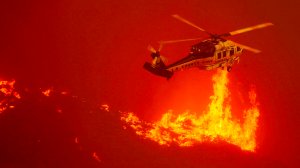 A firefighting helicopter hovers close to the flames from the Sand fire as it burns out of control along Soledad Canyon Road near Acton on Sunday. (Credit: Luis Sinco/Los Angeles Times)