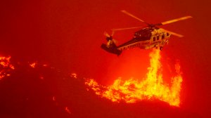 A firefighting helicopter hovers close to the flames from the Sand fire as it burns out of control along Soledad Canyon Road near Acton on Sunday. (Credit: Luis Sinco/Los Angeles Times) 