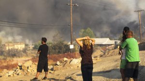 Residents watch in despair as the Blue Cut fire burns homes on the hillside off Highway 138 in Summit Valley. (Credit: Gina Ferazzi / Los Angeles Times)