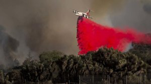 An air tanker drops fire retardant near homes as the Blue Cut fire burns out of control on both sides of Highway 138 in Summit Valley, California. (Credit: Gina Ferazzi / Los Angeles Times)