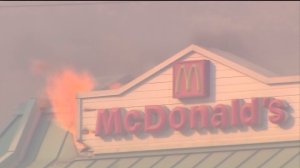 A water drop was made on a McDonald's restaurant off the 15 Freeway as flames ignited the roof on Aug. 16, 2016. (Credit: KTLA)