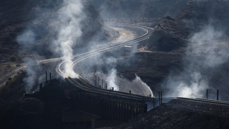 Smoke rises from beneath railroad tracks damaged by the Blue Cut Fire. (Credit: Marcus Yam / Los Angeles Times)