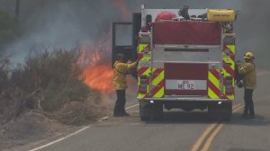 Firefighters arrive just after flames flare up along Highway 173 amid the Pilot Fire on Aug. 8, 2016. (Credit: KTLA)