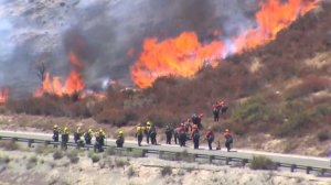 Firefighters face flames from the Blue Cut Fire in the Cajon Pass area on Aug. 16, 2016. (Credit: KTLA)