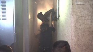 A woman was rescued from a burning home in the Vermont Knolls neighborhood of South Los Angeles on Aug. 9, 2016. (Credit: ANG.News)