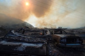 Destroyed cars smolder after the Blue Cut Fire burned a small community near Wrightwood, on Aug. 17, 2016. (Credit: ROBYN BECK/AFP/Getty Images)