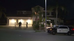 Los Angeles Police Department officials remain at the scene of a shooting in Granada Hills that left one dead and two others injured on Aug. 21, 2016. (Credit: KTLA)