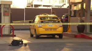 A taxi cab is surrounded by police tape at a gas station in Franklin Village following a fatal attack in which the driver of the cab was killed on Aug. 14, 2016. (Credit: KTLA)