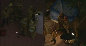 Los Angeles County Firefighters work on both ends of a chimney to try and free a boy who became stuck in a chimney in Lancaster on Aug. 22, 2016. (Credit: KTLA)