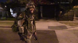 A man in military gear is seen carrying a rifle in Inglewood on Aug. 16, 2016. (Credit: Loudlabs)