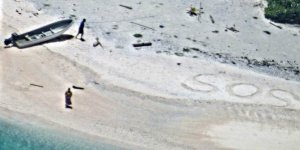 This U.S. Navy photo shows two mariners who were stranded on an uninhabited Pacific island in Chuuk State, Federated States of Micronesia. The pair were rescued after etching "SOS" in the sand. 