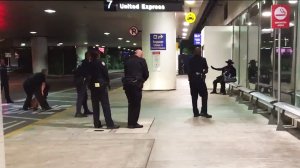 Airport police detain a man in a Zorro costume at LAX on Aug. 28, 2016. (Credit: Sam Macon)