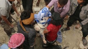 Syrians carry the body of child after pulling it out from under the rubble of a building following bombardment in the northern Syrian city of Aleppo on Sept. 23, 2016. (Credit: Ameer Alhalbi/AFP/Getty Images)