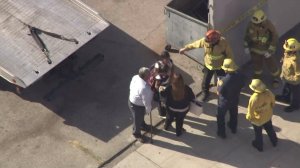 Firefighters talk to a child after crash involving school bus in Arlington Heights on Sept. 22, 2016. (Credit: KTLA)