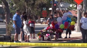 People gather around a bench where a homeless woman who was stabbed Sept. 22, 2016, in Corona regularly sat. (Credit: KTLA)