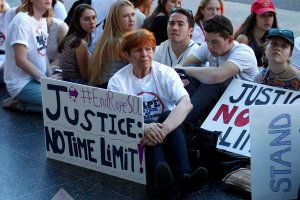 Nadia Sutton holds a sign while listening to artist and actor Lili Bernard speak about allegedly being raped by Bill Cosby. (Credit: Allen J. Schaben/Los Angeles Times)