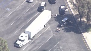 A man who led CHP on an hourslong pursuit of a stolen big rig surrenders on Sept. 13, 2016. (Credit: KTLA)