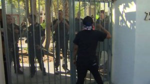 A woman shouts at police officers through a security gate after a man's death in Pasadena on Sept. 30, 2016. (Credit: KTLA)