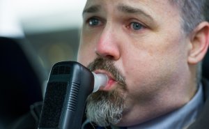 Bill Chastain, state director with LifeSafer, demonstrates a breath alcohol ignition interlock device during a press conference announcing a holiday crack-down on drunk and drugged driving Dec. 17, 2013, in Washington, D.C. (Credit: PAUL J. RICHARDS/AFP/Getty Images)