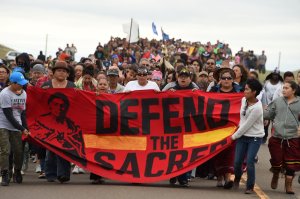 Native Americans march to the site of a sacred burial ground that was disturbed by bulldozers building the Dakota Access Pipeline (DAPL), near the encampment where hundreds of people have gathered to join the Standing Rock Sioux Tribe's protest of the oil pipeline slated to cross the nearby Missouri River, Sept. 4, 2016, near Cannon Ball, North Dakota. (Credit: ROBYN BECK/AFP/Getty Images)