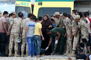 Egyptian policemen and medics stand over a body of a migrant along the shore in the Egyptian port city of Rosetta on Sept. 22, 2016. (Credit: MOHAMED EL-SHAHED/AFP/Getty Images)