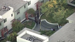 Officers investigate in the courtyard of Orange Grove Gardens in Pasadena on Sept. 30, 2016. (Credit: KTLA)