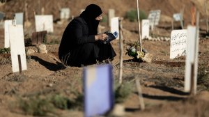 A Syrian woman prays over the grave of her son at a cemetery in the rebel-held town of Douma, east of the capital Damascus, on Sept. 12, 2016, on the first day of the Muslim holiday of Eid al-Adha. (Credit: Sameer al-Doumy/AFP/Getty Images)