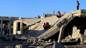 Syrian children slide down rubble of destroyed a building in the rebel-held city of Daraa, in southwestern Syria on Sept. 12, 2016 as Muslims mark the first day of Eid al-Adha holiday. (Credit: Mohamad Abazeed/AFP/Getty Images)