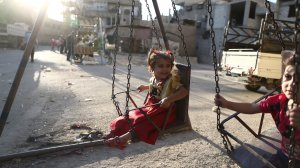 Syrian children play in the street in the rebel-controlled town of Hamouria as they celebrate the third day of the Al-Adha Eid Muslim holiday on the second day of an internally backed ceasefire on Sept. 14, 2016. (Credit: Abd Doumany/AFP/Getty Images)