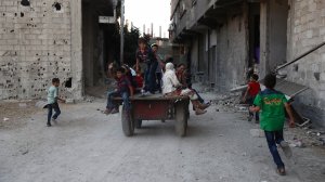 Syrian children play in the street in the rebel-controlled town of Hamouria as they celebrate the third day of the Al-Adha Eid Muslim holiday on the second day of an internally backed ceasefire on Sept. 14, 2016. (Credit: Abd Doumany/AFP/Getty Images)