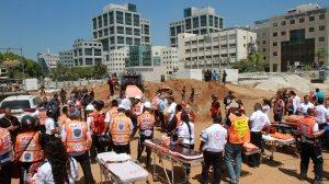 Israeli members of the Magen David Adom rescue service wait next to stretchers after an underground car park collapsed at a construction site on September 5, 2016 in the Ramat Hahayal neighbourhood in the coastal city of Tel Aviv. (Credit: Gil Cohen-Magen/AFP/Getty Images)