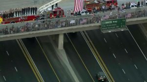 A hearse carrying Sgt. Steve Owen receives a salute on the 14 Freeway on Oct. 6, 2016. (Credit: KTLA)