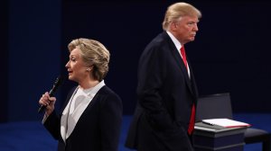 Democratic presidential nominee former Secretary of State Hillary Clinton speaks as Republican presidential nominee Donald Trump listens during the town hall debate at Washington University on Oct. 9, 2016 in St Louis. (Photo by Win McNamee/Getty Images)