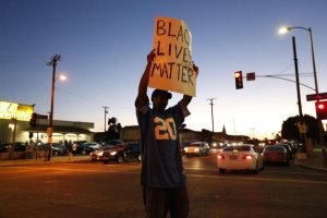 A protestor holds up a sign in South Los Angeles after an officer-involved shooting on Oct. 1, 2016. (Credit: Gary Coronado / Los Angeles Times)