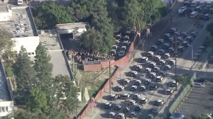 Sheriff's vehicles line the street outside the coroner's office as they await the hearse taking Sgt. Steve Owen's body to Lancaster on Oct. 6, 2016. (Credit: KTLA)