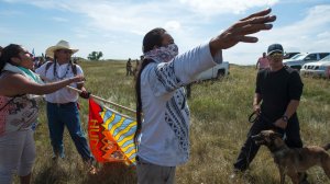 A Native American protestors holds up his arms as he and other protestors are threatened by private security guards and guard dogs, at a work site for the Dakota Access Pipeline (DAPL) oil pipeline, near Cannon Ball, North Dakota, September 3, 2016. (Credit: Robyn Beck/AFP/Getty Images)