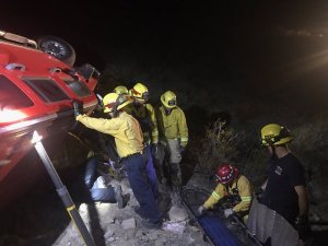 Fire personnel rescue a missing woman from an overturned Hummer in Adelanto in an image posted to the San Bernardino County Fire Department's Facebook page on Oct. 29, 2016.