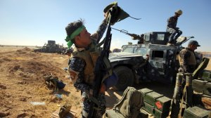 An Iraqi policeman inspects his weapon at the Qayyarah military base, about 35 miles south of Mosul, on Oct. 16, 2016, as they prepare for an offensive to retake the last IS-held city in the country. (Credit: AHMAD AL-RUBAYE/AFP/Getty Images)