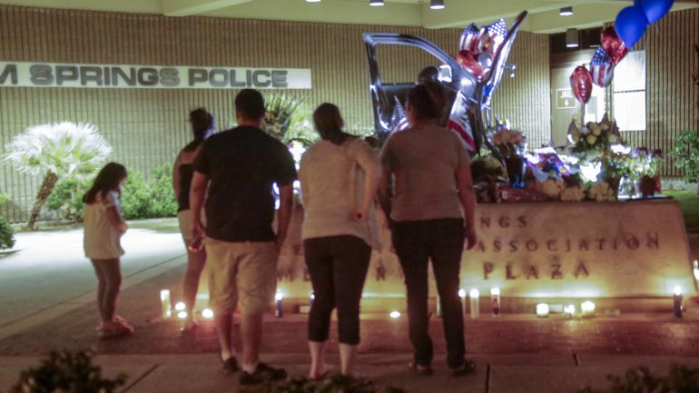 Family members of Palm Springs police officers killed and injured are paying their respect at a memorial set in front of the police station in Palm Springs. (Credit: Irfan Khan / Los Angeles Times)