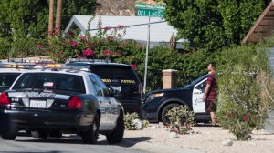 A resident on Del Lago Road watches as a helicopter circles overhead after three police officers were shot in Palm Springs. (Credit: Brian van der Brug / Los Angeles Times)